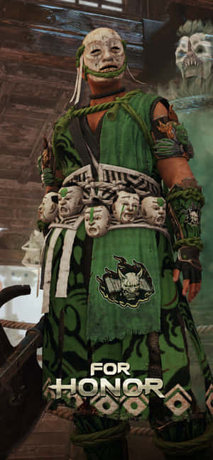 來自遊戲《For Honor》的戰士，身穿綠色盔甲，戴著骷髏面具，腰帶上掛著骷髏。 — Galaxy S22 Ultra 壁紙