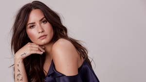 手臂上有刺青的女性將下巴擱在手上。 — 天元突破紅蓮螺巖 壁紙