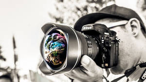 攝影師手持Nikon相機，鏡頭反射色彩繽紛
