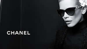 一位時尚女性戴著太陽眼鏡和 Chanel 服裝，在深色背景前。 — 香奈兒 壁紙
