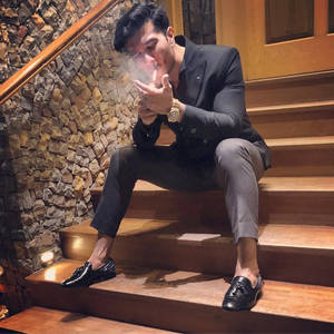 穿西裝男士在木樓梯上吸煙，背景為石牆。 — 抽菸 壁紙