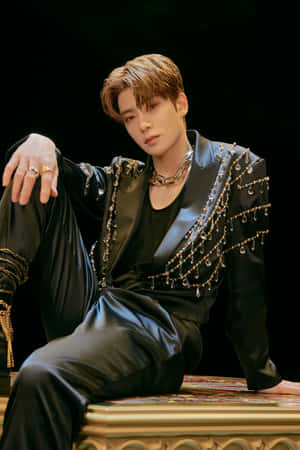 一位時尚男士身穿黑色鑲寶石西裝，坐在華麗的金色長椅上。 — Nct 127 壁紙