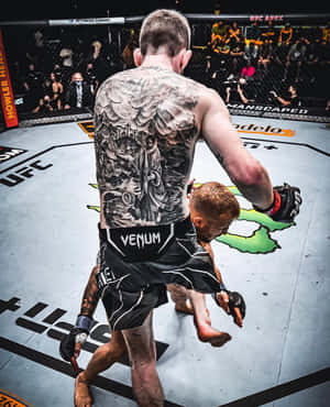 背部有刺青的MMA拳手在UFC八角籠中舉起對手。 — 終極格鬥冠軍賽 壁紙