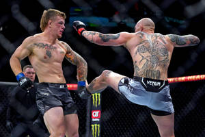 兩位男性MMA拳手在UFC八角籠內對戰，其中一人使出高踢。 — 酷 壁紙