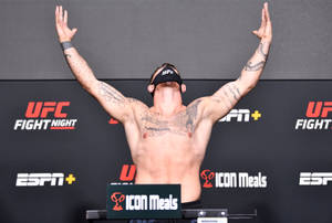 UFC拳手高舉雙臂在稱重活動中慶祝。 — 運動 壁紙