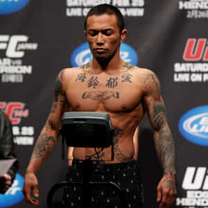有刺青的UFC拳手在稱重活動中站在體重計上。 — 終極格鬥冠軍賽 壁紙