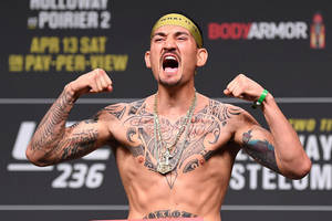有刺青的MMA拳手在稱重活動中舉起拳頭咆哮。 — 運動 壁紙