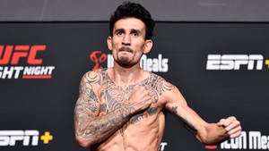 有刺青的UFC拳手在稱重活動中擺姿勢，背景有ESPN和UFC標誌。 — 終極格鬥冠軍賽 壁紙