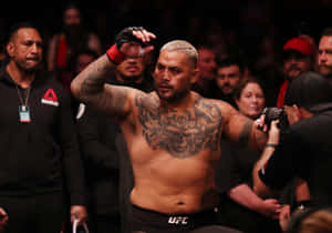有刺青的MMA拳手在擠滿觀眾的場館中慶祝勝利。 — 安卓 壁紙