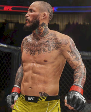 紋身UFC拳手，身穿黃色短褲和黑色手套，在八角籠內。 — 終極格鬥冠軍賽 壁紙