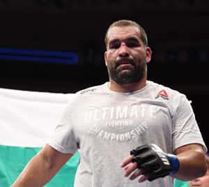 UFC拳手臉部瘀傷在八角籠中，身穿灰色T恤和黑色手套。 — 運動 壁紙