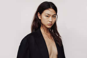 一位穿著黑色西裝外套的女士在攝影棚中直視鏡頭。 — 森林 壁紙