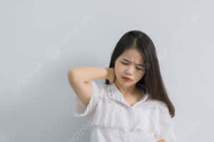 年輕女性不適地按著脖子，表情痛苦。 — 疼痛 壁紙
