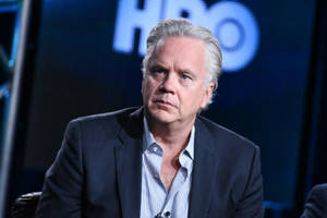 男子身穿西裝在HBO活動中表情嚴肅 — HBO 壁紙