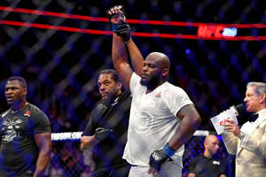 UFC拳手在八角籠中舉拳慶祝勝利。 — 終極格鬥冠軍賽 壁紙
