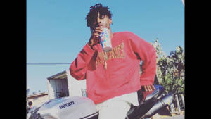 身穿紅色運動衫的年輕男子靠著白色Ducati機車，從罐中飲用。 — Playboi carti 大頭貼 壁紙