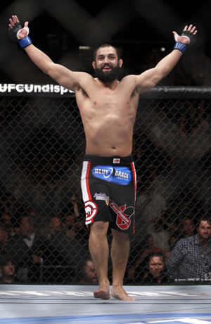 MMA拳手在UFC八角籠內舉臂慶祝勝利 — 終極格鬥冠軍賽 壁紙