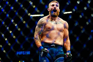留鬍子的MMA拳手在明亮的八角籠中慶祝勝利。 — 運動 壁紙
