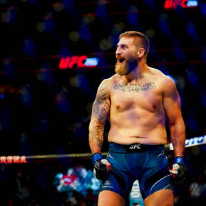 UFC拳手在藍色競技場燈光下於八角籠中慶祝勝利。 — 運動 壁紙