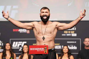 UFC拳手在稱重活動中舉起雙臂慶祝勝利。 — 終極格鬥冠軍賽 壁紙