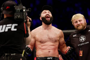 UFC拳手與工作人員及攝製組在八角籠內慶祝勝利。 — 終極格鬥冠軍賽 壁紙
