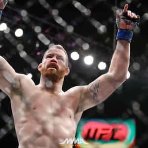 MMA拳手在八角籠內高舉拳頭慶祝勝利。 — 高清 壁紙