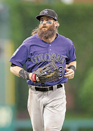 留鬍鬚的棒球運動員穿著紫色科羅拉多球衣在場上奔跑。 — 運動風 壁紙