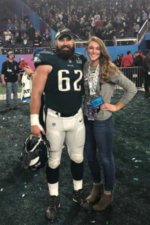 足球運動員和女性在比賽後於體育場上擺姿勢。 — NFL 美式足球 壁紙