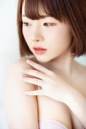 短棕髮的年輕女性在柔和光線中觸碰她的肩膀。 — 模特兒 壁紙