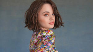 年輕女性穿著花卉上衣在攝影棚轉頭看向相機 — 喬伊·金 壁紙