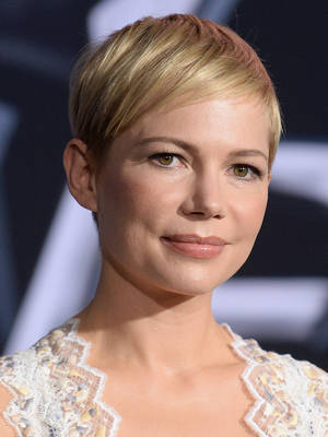 短金髮女性穿著蕾絲上衣對著鏡頭微笑。 — 小威廉絲 壁紙