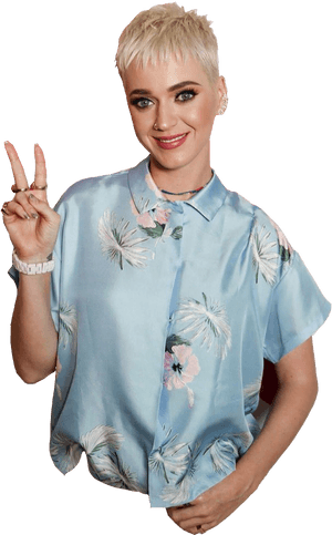 短金髮女性微笑著在花卉襯衫中比出和平手勢。