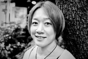 一位女性在黑白照片中靠著樹微笑。 — 終極格鬥冠軍賽 壁紙