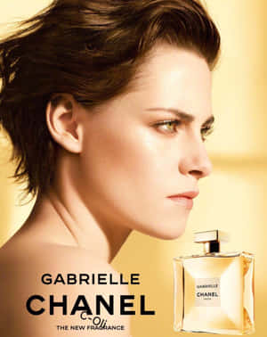 金色燈光下，短髮女性與 Gabrielle Chanel 香水瓶並列。 — 香奈兒 壁紙