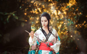 穿著和服的女性在金色陽光的森林中手持武士刀。 — 日本武士 壁紙