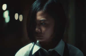 穿著校服的年輕女子在光線昏暗、有燈光的房間裡表情嚴肅。 — 東京喰種風格 壁紙