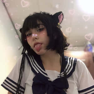 穿著水手服、戴著貓耳的人伸出舌頭，周圍有閃爍的心形。 — 垃圾美學 壁紙