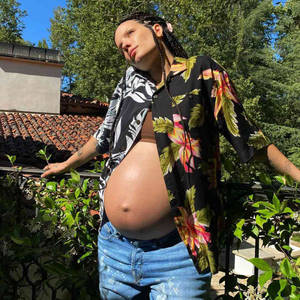 孕婦穿花卉襯衫在晴天戶外站立 — 花園 壁紙