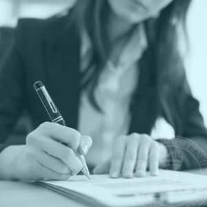 人在辦公桌前用鋼筆簽署文件。 — 閱讀 壁紙