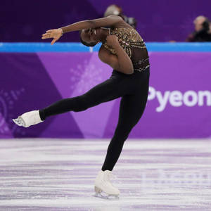 花式滑冰選手在比賽中於冰上展現優雅姿勢。 — 運動 壁紙