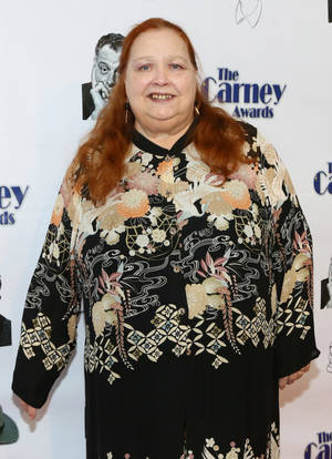 穿著花卉連衣裙的女性在Carney Awards活動中微笑。 — 女演員 壁紙