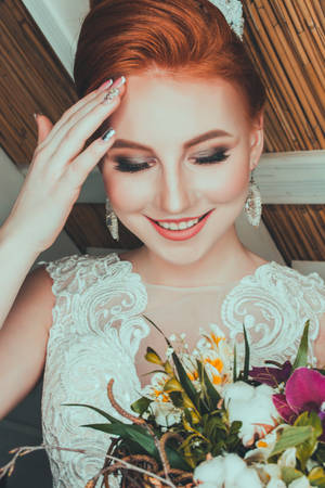 一位穿著白色蕾絲裙的新娘微笑著手持花束。 — 婚紗 壁紙