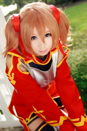 身穿紅金色服裝、橙色雙馬尾的動漫cosplayer，戶外。 — 小米18 Fold 壁紙