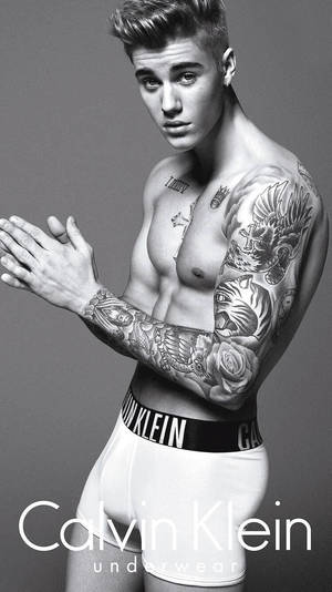 一位有刺青的男子穿著Calvin Klein內衣為時尚照片擺姿勢。 — 小賈斯汀 壁紙
