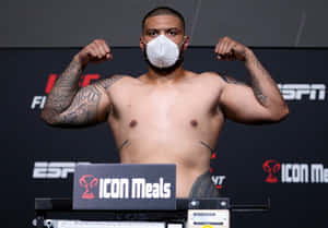 一位戴著口罩的UFC拳手在帶有ESPN和ICON Meals品牌的稱重活動中展示肌肉。 — 終極格鬥冠軍賽 壁紙