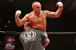 一位勝利的MMA拳手在籠中被教練舉起。 — 運動 壁紙