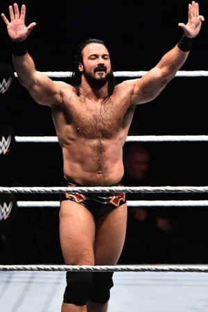 摔角手在摔角場上高舉雙臂慶祝勝利。 — WWE GIF 壁紙