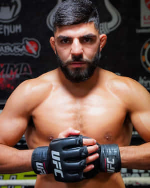 一位專注的男性MMA拳手在健身房中戴著UFC手套。 — 運動 壁紙