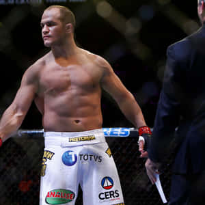 肌肉發達的MMA拳手穿著白色短褲站在八角籠內。 — 運動 壁紙