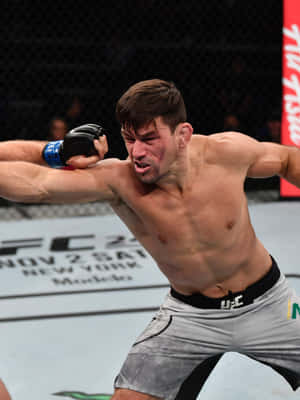 一名男性MMA拳手在比賽中於UFC八角籠內揮拳。 — 終極格鬥冠軍賽 壁紙
